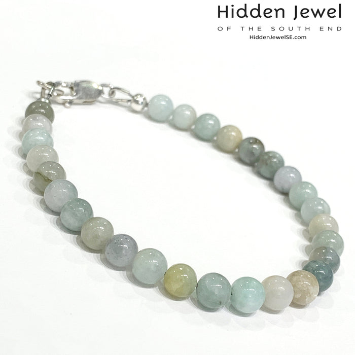 A Burma jade gemstone beaded bracelet with sterling silver  lobster claw on white background, front right angle overview.