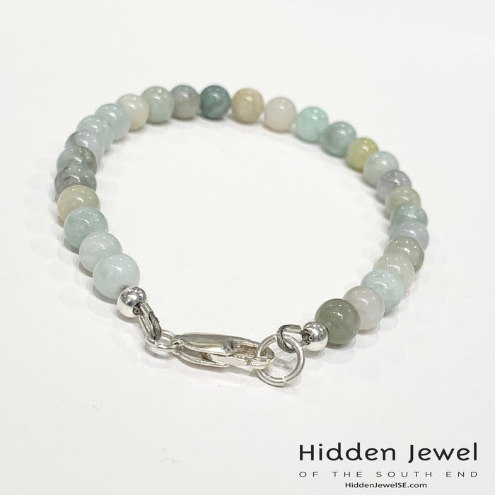 A Burma jade gemstone beaded bracelet with sterling silver  lobster claw on white background, back  angle overview.