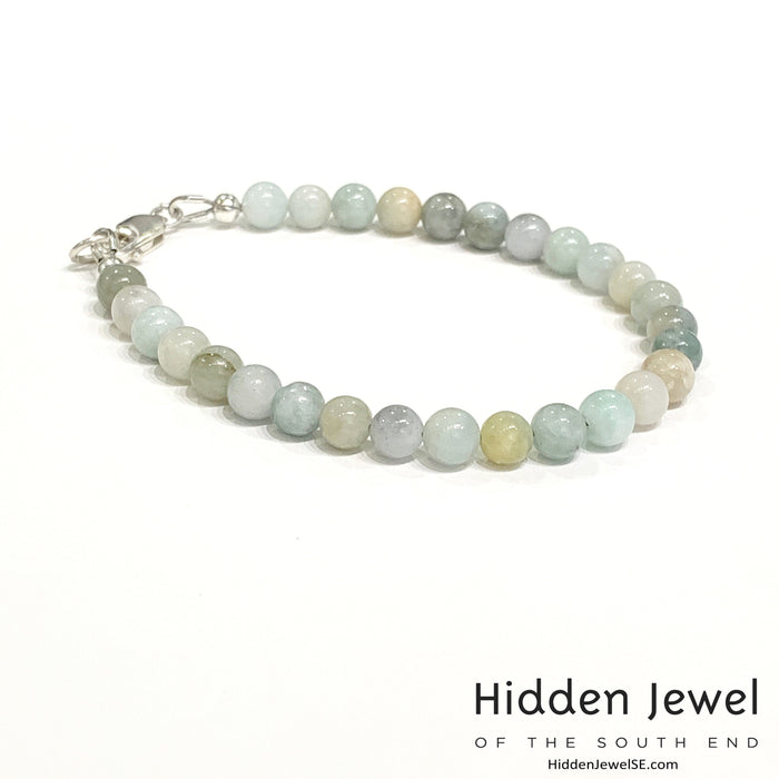 A Burma jade gemstone beaded bracelet with sterling silver  lobster claw on white background, right side angle overview.