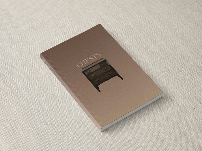 The Chests book lying closed on a canvas surface