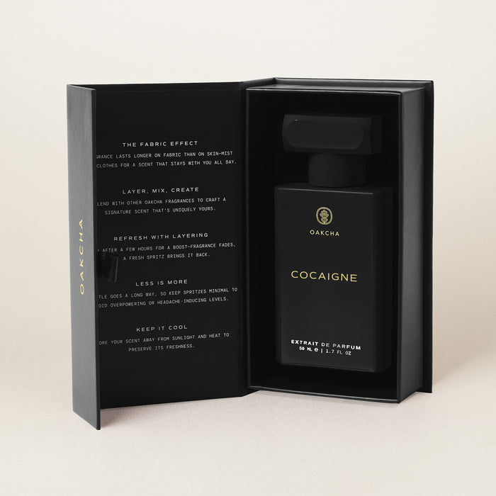 Front view of Cocaigne Extrait de Parfum bottle showcasing 50 ml black packaging in an open presentation box