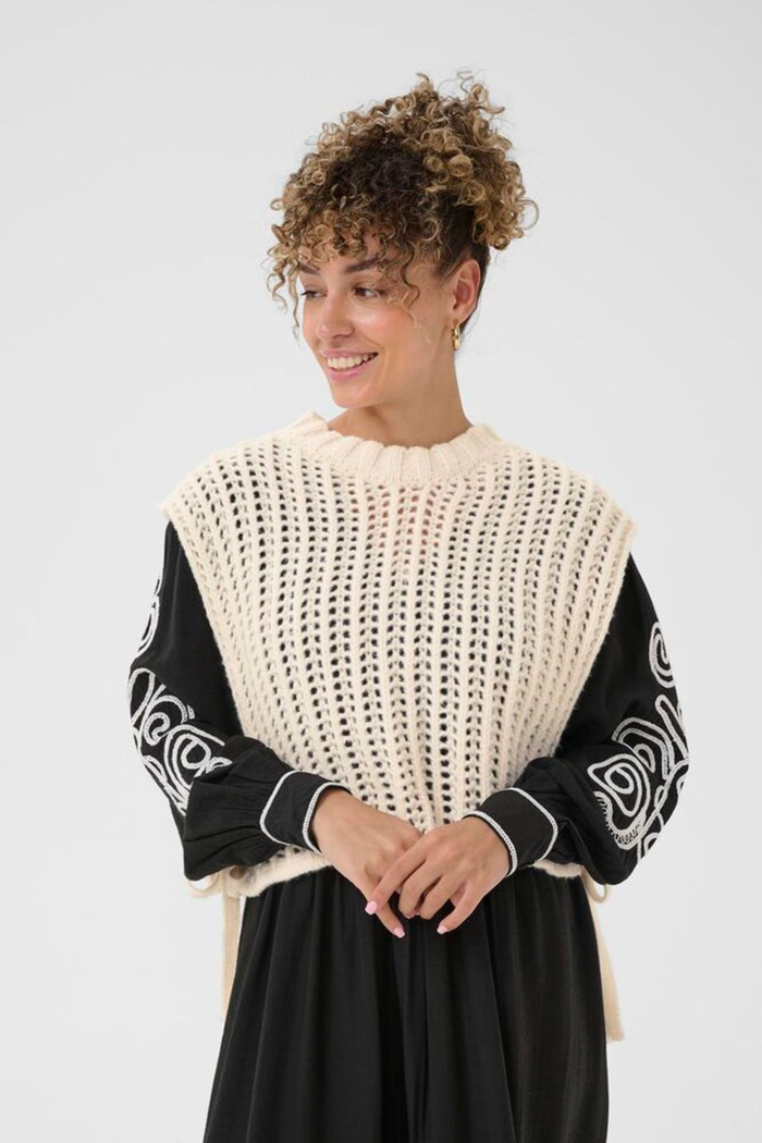 Lightweight open knit slipover in whisper white by Cream. Easy to layer with shirts or dresses for relaxed everyday style. Shop at Dotique.