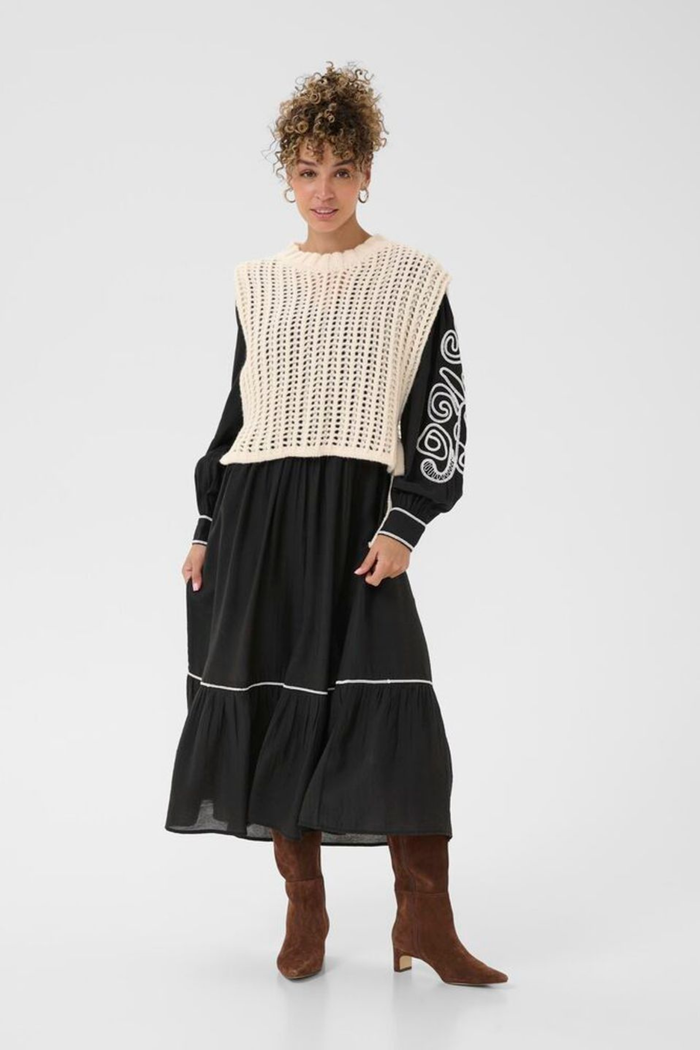 Lightweight open knit slipover in whisper white by Cream. Easy to layer with shirts or dresses for relaxed everyday style. Shop at Dotique.