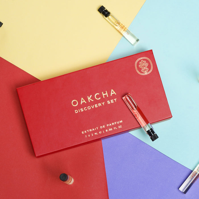 Angled top of Oakcha Discovery Sample Set showing red box with gold logo, 7x2ml and a sample vial on colorful background