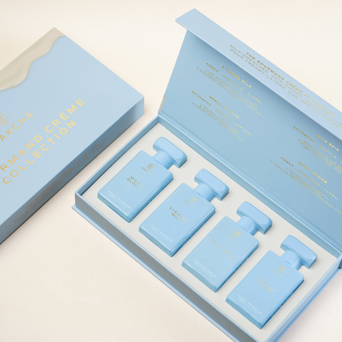 Angled view of the Gourmand Creme Collection Set showcasing four blue extrait de parfum bottles in an open presentation box
