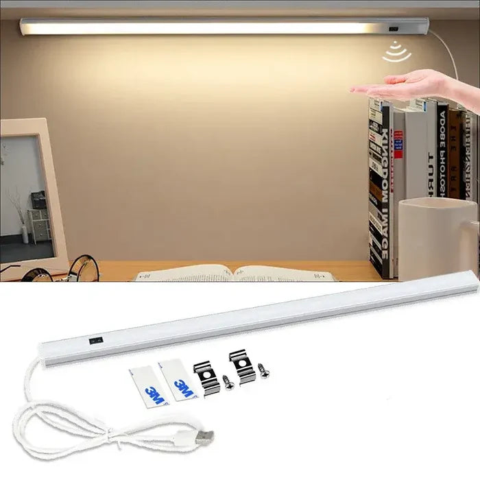 A hand is holding a light that is attached to a wall