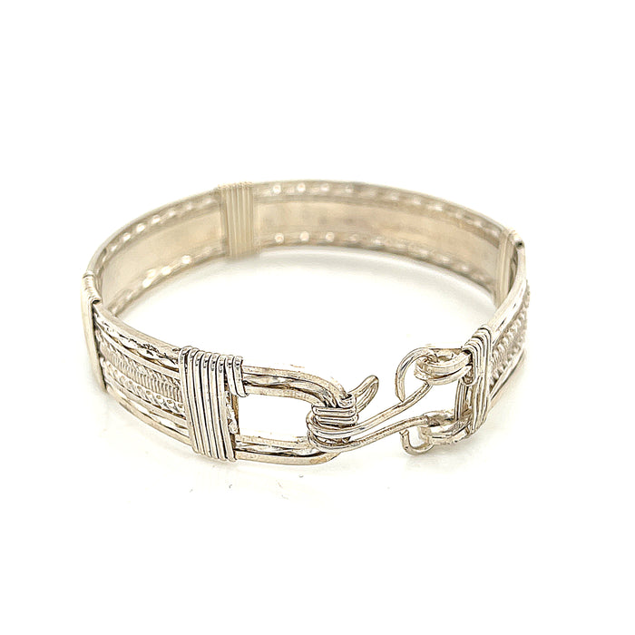 Style #1 Handcrafted sterling silver wire-wrapped bangle with twisted and straight wire combination showing polished dome centerpiece, on a white background, close up  back view.