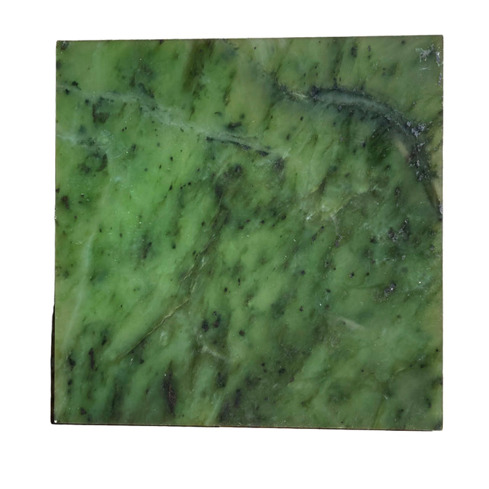 Green jade stone slab on a wooden surface