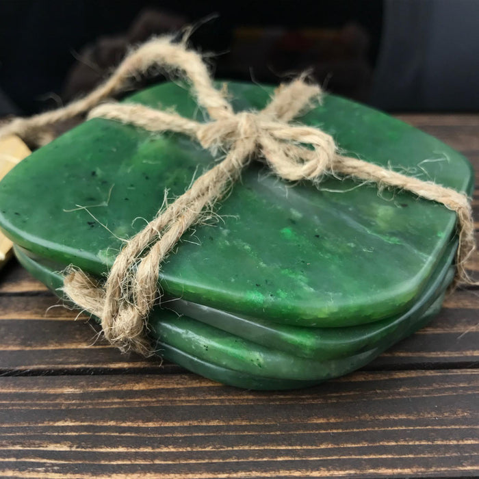 Green jade coasters tied with twine on a wooden surface