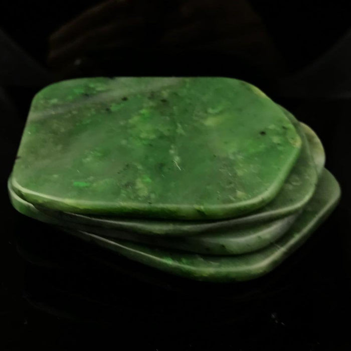 Stack of green jade slabs on a black background