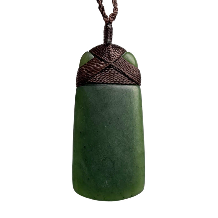 Green stone pendant with brown cord on a white background