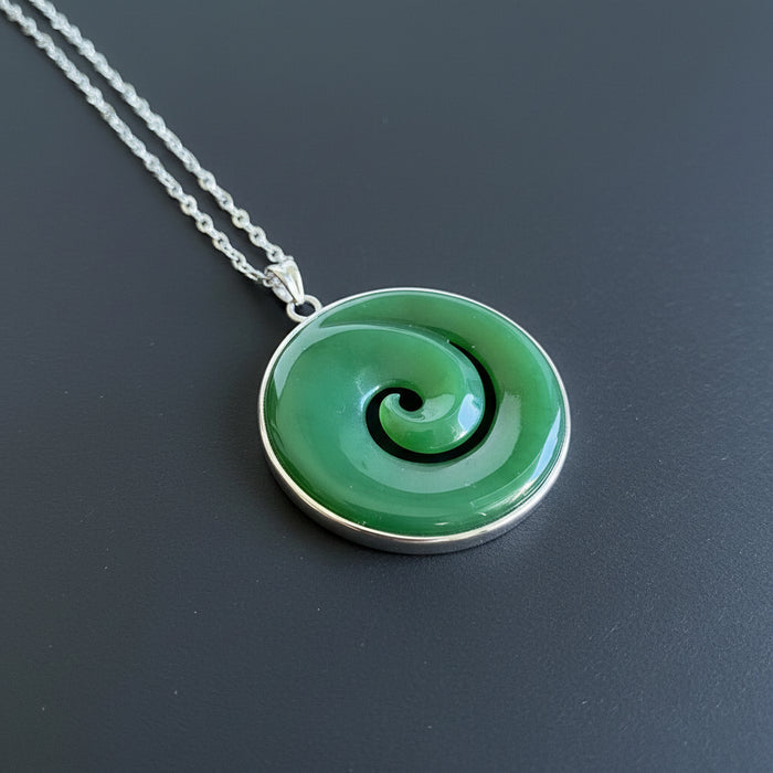 Green spiral pendant on a chain with dried flowers on a wooden surface