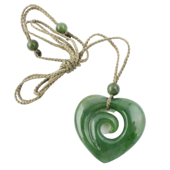Green jade heart-shaped pendant on a string against a white background