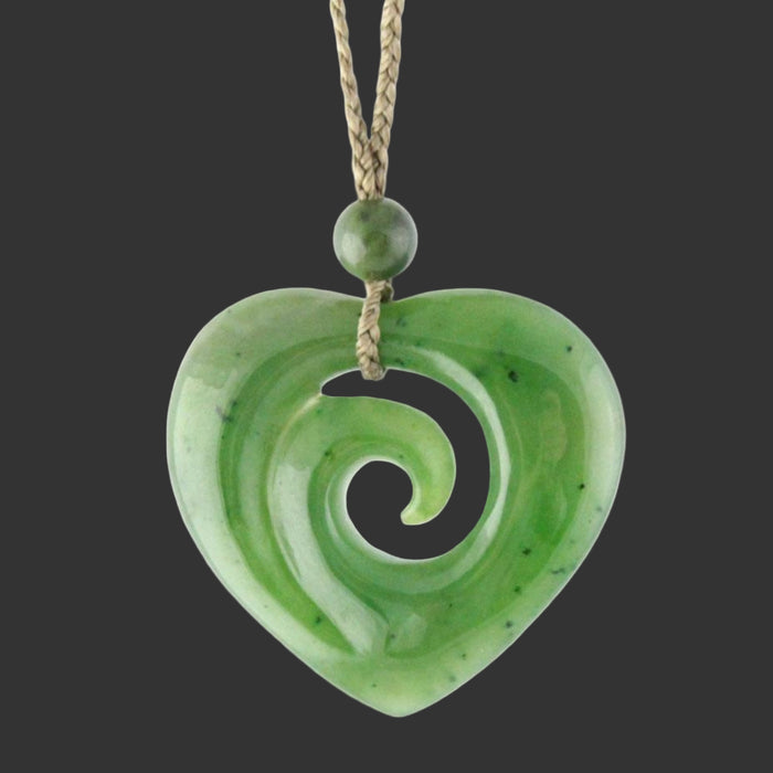 Green jade heart-shaped pendant with spiral design on a white background