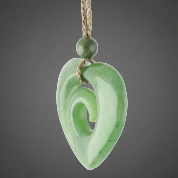 Green jade spiral pendant on a white background