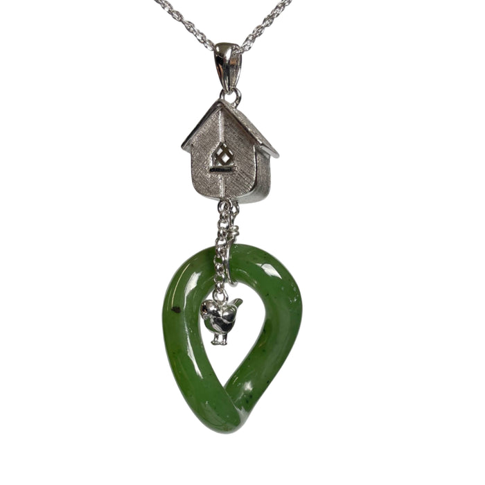 Green jade pendant with silver birdhouse and bird charm on a white background