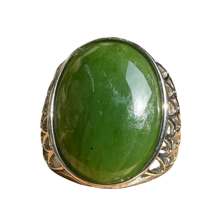 Green stone jade ring on a wooden surface with a natural background
