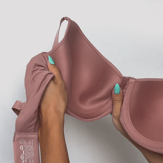 Hands stretching the fabric of the Padded Flexiwire Bra in mauve to show the give in the material