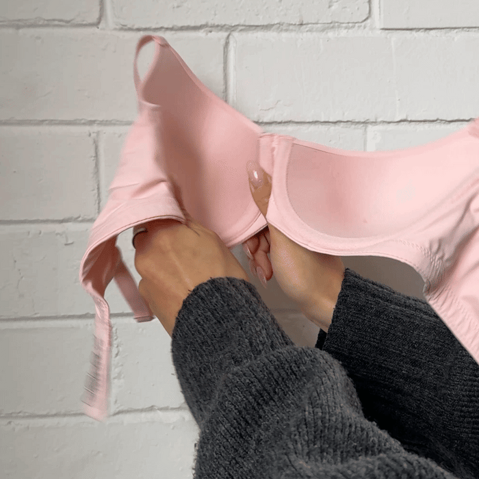 Hands stretching the fabric of the Padded Flexiwire Bra in pale pink to show the give in the material