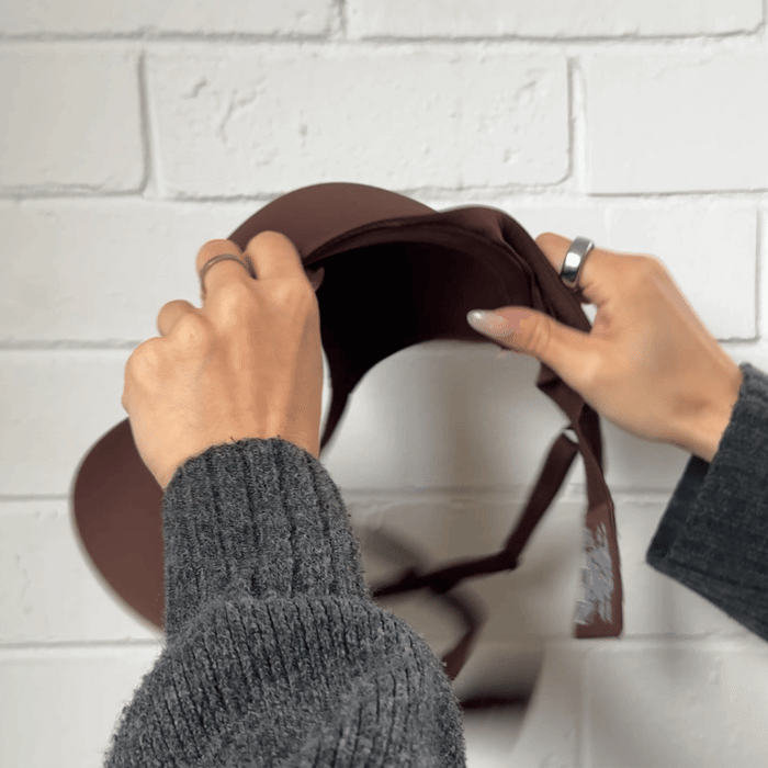 Hands stretching the fabric of the Padded Flexiwire Bra in burgundy to show the give in the material