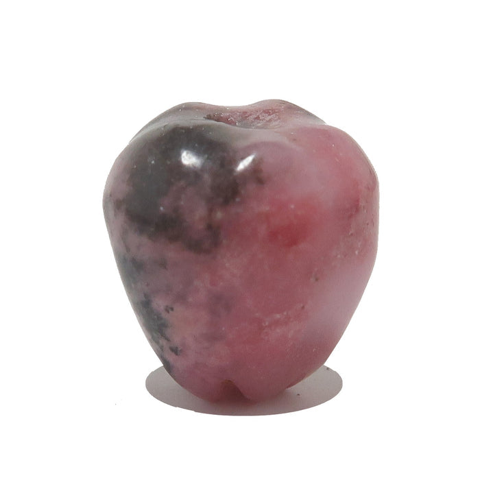 Pink Rhodonite apple stone with a rough texture on a white background