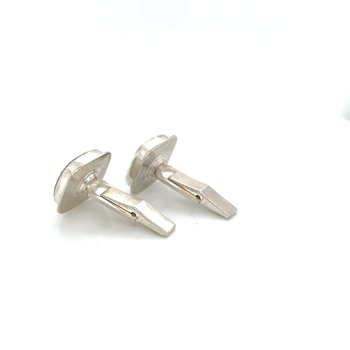 Close-up of natural quartz crystal, druzy texture, with brown inclusions, gemstone, with sterling silver cufflinks on a white background, back side  close up overview.
