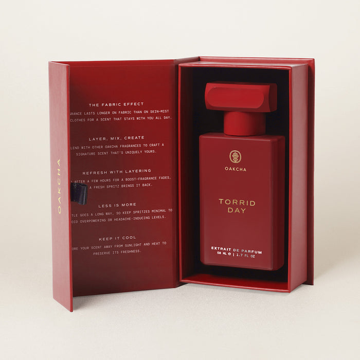 Front view of Torrid Day 50 ml Extrait de Parfum bottle in an open red presentation box